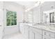 Bathroom with white cabinets, double vanity, marble countertops, and a large window at 486 Lantana Circle, Georgetown, SC 29440