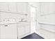 Laundry room with white cabinets and tile flooring, next to a bathroom at 486 Lantana Circle, Georgetown, SC 29440