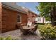 Brick house backyard with a stone patio, outdoor table, chairs, and landscaped surroundings at 618 6Th Ave. N, Surfside Beach, SC 29575