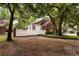 Backyard with mature trees surrounding a brick house and white picket fence at 618 6Th Ave. N, Surfside Beach, SC 29575