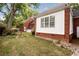 Backyard of a brick house with a lawn, small trees, and a white-painted section at 618 6Th Ave. N, Surfside Beach, SC 29575