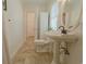 Bathroom featuring a pedestal sink, tiled floors, and a view into the hallway with doors at 618 6Th Ave. N, Surfside Beach, SC 29575