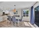 Sunlit dining room with a modern chandelier, lots of seating, hardwood floors, and a sliding glass door at 800 9Th Ave. S # A-4, North Myrtle Beach, SC 29582