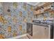 Convenient laundry room featuring modern washer and dryer with lemon-themed wallpaper and shelving at 800 9Th Ave. S # A-4, North Myrtle Beach, SC 29582