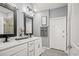 Bathroom with double sink vanity, modern lighting, framed mirrors, and decorative towel racks at 830 San Marco Ct. # 2603-B, Myrtle Beach, SC 29579