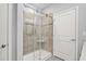 Modern tiled shower in a bathroom featuring a glass door, built-in shelves, and a white door at 830 San Marco Ct. # 2603-B, Myrtle Beach, SC 29579