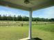 A covered patio overlooks a expansive backyard with a pond and view of the surrounding treeline at 958 Oak Hollow St., Longs, SC 29568
