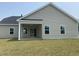Backyard with covered patio, manicured lawn, and a home with vinyl siding at 962 Oak Hollow St., Longs, SC 29568