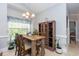 Bright dining area features a wood table, decorative chandelier, and natural light streaming in from the window at 100 Birch N Coppice Dr. # 12, Surfside Beach, SC 29575