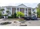 Three-story condo with brick accents, white columns, stairs, and ample parking at 100 Birch N Coppice Dr. # 12, Surfside Beach, SC 29575
