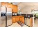 Well-lit kitchen features stainless steel appliances, wooden cabinetry, and tile floors at 100 Birch N Coppice Dr. # 12, Surfside Beach, SC 29575