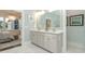 Well-lit bathroom with double vanity sinks, white cabinets and large decorative mirror at 1079 Milford Way, Myrtle Beach, SC 29588