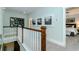 Bright hallway features beach themed art, wood banister, neutral walls, and plush carpeting at 1079 Milford Way, Myrtle Beach, SC 29588
