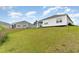 View of the backyard and back of house on a grassy lawn, a bird feeder, and trees at 1135 Sennema Circle, Myrtle Beach, SC 29588