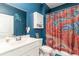 Bathroom with dark blue walls, white cabinets and sink, and a fun octopus-themed shower curtain at 1135 Sennema Circle, Myrtle Beach, SC 29588