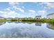 Community pond with reflections of neighborhood houses and a blue, cloudy sky at 1135 Sennema Circle, Myrtle Beach, SC 29588