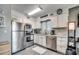 Kitchen with white cabinets, stainless steel appliances, and gray tiled floors at 1208 S Ocean Blvd. # H, North Myrtle Beach, SC 29582