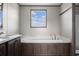 Spa-like bathroom with tub, wood cabinets, white countertop, and brushed nickel faucet at 121 Forman Way, Aynor, SC 29511