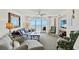 Living room featuring comfortable seating, ceiling fan, and view to ocean through glass doors at 1401 S Ocean Blvd. # 506, North Myrtle Beach, SC 29582
