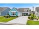 Charming one-story home with a colorful exterior, well-manicured lawn, and a long concrete driveway at 143 Starlit Way, Myrtle Beach, SC 29579