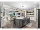 Open-concept kitchen with dark gray island, stainless appliances, and hardwood floors at 143 Starlit Way, Myrtle Beach, SC 29579