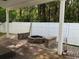 Covered backyard patio featuring a stone fire pit, brick benches, and fenced yard at 1440 Brighton Ave., Myrtle Beach, SC 29588