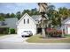 Charming two-story home with landscaped yard, garage, and a white car in the driveway under a sunny blue sky at 1440 Brighton Ave., Myrtle Beach, SC 29588