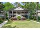Charming two-story home with double porches, American flags, lush landscaping, and a well-manicured lawn at 146 Stillwood Dr. # 3, Pawleys Island, SC 29585