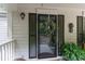 A cozy front porch featuring a decorative wreath, black shutters, and potted plants at 146 Stillwood Dr. # 3, Pawleys Island, SC 29585