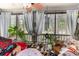 Inviting screened porch with a ceiling fan, curtains, wind chimes, and natural light at 146 Stillwood Dr. # 3, Pawleys Island, SC 29585