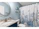 Stylish bathroom features granite counters, blue vanity, round mirror, and nautical shower curtain at 1610 Old Tram Rd., Little River, SC 29566