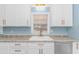 Bright kitchen features white cabinets and countertop with gold faucet and hardware at 1931 Jasper St., Georgetown, SC 29440