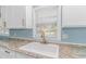Bright kitchen features white cabinets and countertop with gold faucet, and hardwood floors at 1931 Jasper St., Georgetown, SC 29440