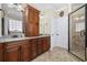 Bathroom featuring double vanity with granite countertop, cherry cabinets and a tiled shower at 200 Stonefly Ct., Murrells Inlet, SC 29576