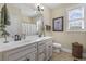 Bright bathroom with double sink vanity, white cabinetry, decorative mirror and tile flooring at 200 Stonefly Ct., Murrells Inlet, SC 29576