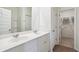 Bright bathroom with double sinks, white cabinetry, and a view into a walk-in closet at 2112 Victory Way # 560, Myrtle Beach, SC 29579