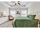 Bright bedroom boasts a tray ceiling, windows bringing in natural light, and a comfortable green comforter on an iron bed frame at 240 Hillsborough Dr., Conway, SC 29526