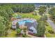 Aerial view of a community pool with a lounge area, playground, and surrounding lush landscaping at 240 Hillsborough Dr., Conway, SC 29526