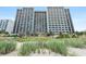 High-rise condo building with a view from a sandy beach and green sea grass at 2401 S Ocean Blvd. S # 267, Myrtle Beach, SC 29577