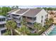 Aerial view of a multi-story condo building with palm trees and a nearby construction site at 250 Maison Dr. # J-11, Myrtle Beach, SC 29572