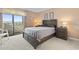 Comfortable bedroom with neutral tones, large window, balcony, and coordinating furnishings at 250 Maison Dr. # J-11, Myrtle Beach, SC 29572