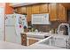 Kitchen features wood cabinets, white appliances, and tile backsplash at 250 Maison Dr. # J-11, Myrtle Beach, SC 29572