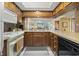 Kitchen with warm wood cabinets, laminate countertops, and appliances with view into living room at 250 Maison Dr. # J-11, Myrtle Beach, SC 29572