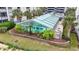 A sunroom encloses the lovely community pool, surrounded by mature palm trees and tropical landscaping at 250 Maison Dr. # J-11, Myrtle Beach, SC 29572