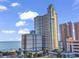 Coastal condo building with blue accents, ocean view, palm trees, and beach access for a luxurious vacation experience at 2504 N Ocean Blvd. # 934, Myrtle Beach, SC 29577