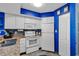 Cozy kitchen featuring white cabinets, mosaic backsplash, blue accents, and matching white appliances at 2504 N Ocean Blvd. # 934, Myrtle Beach, SC 29577