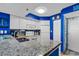 Functional kitchen boasts granite countertops, white cabinetry, blue accents and stainless steel sink at 2504 N Ocean Blvd. # 934, Myrtle Beach, SC 29577