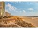 Scenic view of a sandy beach with lifeguard stand, resort, and ocean at 300 N Ocean Blvd. # 1732, North Myrtle Beach, SC 29582