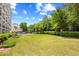 View of the community pool and yard space, with lush landscaping and blue skies at 311 71St Ave. N # 3-D, Myrtle Beach, SC 29572