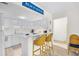 Bright white kitchen features a breakfast bar with wicker chairs, wood floors, and 'Beach House' decor at 311 71St Ave. N # 3-D, Myrtle Beach, SC 29572